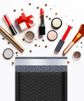 Black Bubble Mailers 5x8.6 Inch Outer Size With 5x7 Inch Inner, 50 Pack Padded Self Seal Envelopes, surrounded by makeup items.