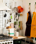 Double Pack Metal Pegboard Panels for Walls, Modular Pegboard Wall Organizer in kitchen with utensils and aprons, white finish