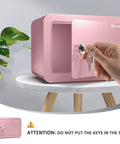 Hand opening Pink Home Safe Box For Kids And Money, Compact Lock Box With Key, 6.69 x 9.06 x 6.69 inches, on table
