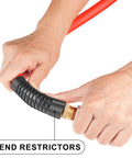 Hands connecting bend restrictors on Boss Level Heavy Duty Half Inch By Fifty Foot Hybrid Air Compressor Hose Rated At 300 Psi.