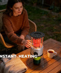 Woman using 8,500 BTU Portable Propane Heater For Outdoors With Tilt Switch And Two Speed Heating on a table in a garden setting.