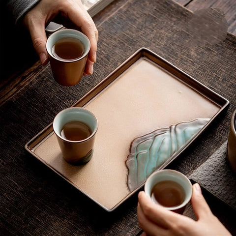 Premium Ceramic Tea Serving Tray For Kung Fu Brewing And Coffee Or Cocktails with tea cups in hand on wooden table