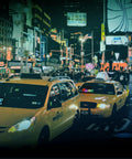 Two yellow taxis with bright city lights in the background, capturing a vibrant night scene with advertising billboards.