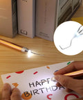 Person using a lighted vinyl weeding tool from the Lighted Vinyl Weeding Tools Set 3 Piece Pin And Hook Led Pen for crafting