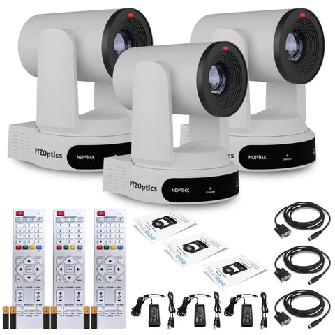 Three Pack Heavy Hitter 4K PTZ Camera With 30X Optical Zoom And Slick Auto Tracking Capabilities Featuring SDI And HDMI And USB Ports For Kickass Live Streaming And Dope Video Production Setups In Sharp White Finish on a table with remotes and cables.