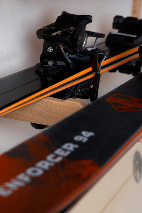 Top Shelf Heavy Duty Bamboo Ski Wall Mount Rack For Garage Storage holding black skis with vibrant orange accents.