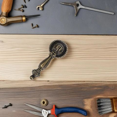 Vintage Zinc Alloy Cabinet Handle Single Hole Round Antique Pull With Bronze Finish shown on a wooden surface with tools.