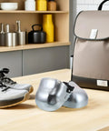 Built Different Steel Toe Caps For Work Boots That Lock Down Your Toes On The Daily Heavy Duty Overshoe Cover for men and women, silver color, placed beside gray work shoes.