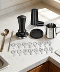 All-In-One 58mm Espresso Accessories Kit With Spring-Loaded Calibrated Tamper, WDT Tool, Milk Pitcher, Latte Art Pen, Spoon, Tamper Mat, and 16 Latte Art Stencils for Delonghi 58mm Espresso Machines and Portafilters on kitchen counter.