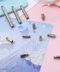 Heavy Duty 20 Piece Scrapbook Extension Posts And Bookbinding Screws Rust Proof Copper 12 Millimeter Spacer Rings for Plug And Play Photo Album Refills, shown on a colorful background.