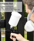 Built Tough Premium LVLP Paint Spray Gun Featuring Slick Teflon Coated Aluminum Body With Three Interchangeable Tips delivering precise painting on a black fence.