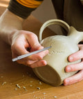 Person using Solid Heavy Duty Tungsten Carbide Scriber With Retractable Clip Etching Pen on clay pot.