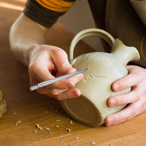Person using Solid Heavy Duty Tungsten Carbide Scriber With Retractable Clip Etching Pen on clay pot.