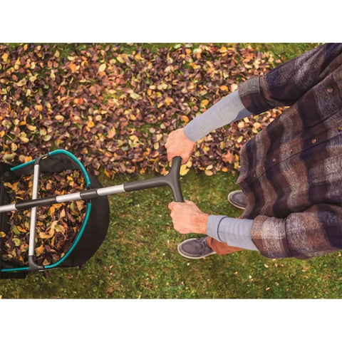Man using Durable Lawn Sweeper For Leaves And Grass Clippings, No Fuss Maneuvering 3.2 Cu Ft Mesh Hopper on autumn lawn