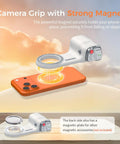 Phone Camera Grip For iPhone Pro Max With Thumb Rest Enhanced Mount And Detachable Remote on table with orange phone
