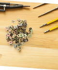 Premium Gold U Shaped Automotive Fasteners 50 Piece Set Replacement Panel Mounting Clips For Cars And Trucks With Vibration Resistant License Plate Hardware That Keeps Your Ride Rock Solid And Looking Crisp, showing gold fasteners on wooden surface.