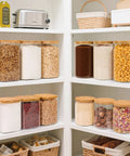 Two Pack 3.6 Qt Square Glass Food Storage Jars With Lids A Kitchen Must Have For Flour Sugar Rice Pasta Oats Coffee Beans Keeps Your Pantry Organized And Fresh Clear See Through Design, neatly arranged on white pantry shelves filled with various dry goods.