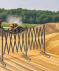 Straight Up Heavy Duty Expandable Metal Barrier On Wheels, Adjustable Retractable Safety Fence For Crowd Control, Rolling Traffic Gate With Locking Casters, Foldable Industrial Yard Barrier, Coffee Brown in construction site setting.