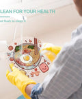 Person rinsing colorful tempered glass cutting board counter protector under running water for easy clean up