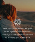 Couple wrapped in a blanket watching sunset over desert dunes, text overlay reads 'Brighter Way, 1973' with quality ingredients message.