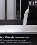 Close-up of white Ceramic Pro Resin for 3D printing pouring into a tray, showcasing ultra low viscosity for precise printing.