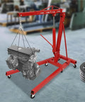 Heavy Duty Garage Workhorse: 2 Ton Hydraulic Engine Hoist With Adjustable 0.5 To 2T Range lifting an engine in a workshop.
