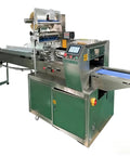 Flow Wrapper Compact Packaging Machine With 50 To 80 Pieces Per Minute, stainless steel design, for snack and home packaging use.