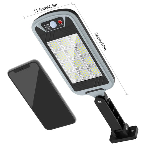 Lit Up Solar Flood Lights Outdoor With 168 LED 6500K Dusk Till Dawn Eight Sided Motion Sensor next to smartphone