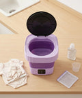 Top Slick 6 Liter Portable Mini Washer Folds Flat For Cramped Dorm Spaces with open lid and folded baby clothes.