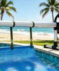 Rock Solid Eight Piece Pool Cover Reel Mounting Kit With Heavy Duty Army Green Straps And Slick Clips For Solar Covers attached to a pool.