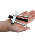 Hand holding a compact Steering Wheel Puller Kit For Quick No Hassle Removal, Durable Steel Construction, Fits Most Makes And Models.