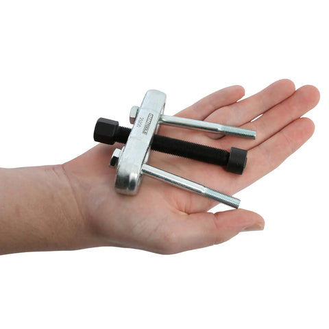 Hand holding a compact Steering Wheel Puller Kit For Quick No Hassle Removal, Durable Steel Construction, Fits Most Makes And Models.