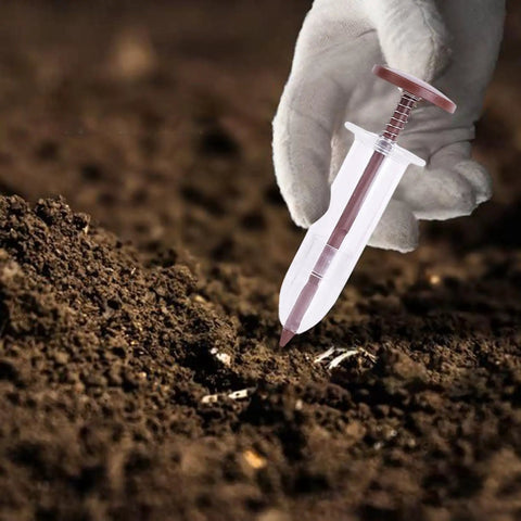 Portable Handy Ergonomic Seed Spreader And Seeder Tool For Lawn And Garden, shown in use with soil in a gardening setting.