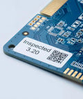 Close-up of printed circuit board with inspection label and QR code, showcasing electronic components.