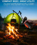 Using Cordless Air Duster With 60 MPH Wind Power Portable Mini Blower next to campfire and green tent outdoors.