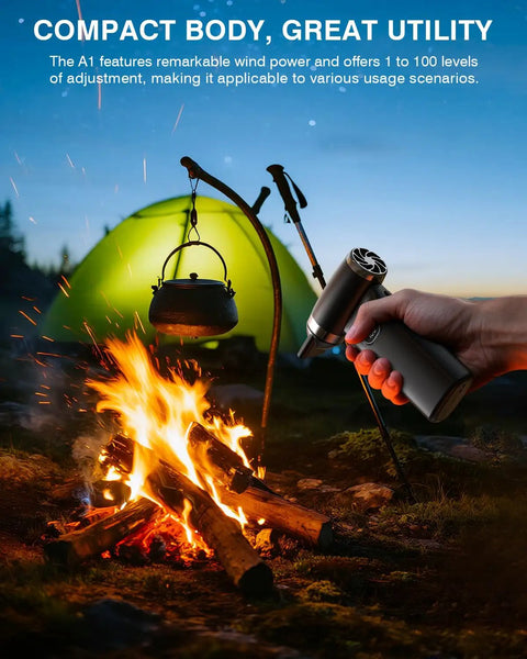 Using Cordless Air Duster With 60 MPH Wind Power Portable Mini Blower next to campfire and green tent outdoors.