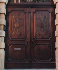 Ten Pack 6 Inch Metal Bow Door Handles Black Matte Vintage Barn Door Pulls installed on ornate wooden double doors