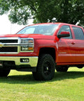 Red Chevy Silverado equipped with 2 Inch Red Aluminum Leveling Kit For Chevy And GMC 1500 2007 To 2018 Level Front To Rear