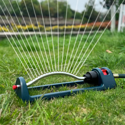 Beefy Base Oscillating Lawn Sprinkler with 18 brass nozzles on grass, showing water spray pattern and hose connector
