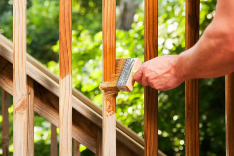 Hand using Dope 3 Inch Block Stain Brush For Deck And Fence Staining Thick Flat Paint Brush With Soft Bristle Blend on wooden railing