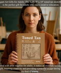 Person holding Tan Toned Sketchbook For Mixed Media With Sixty Sheets Of 90lb 150gsm Tan Drawing Paper 5.5 By 8.5 Inches Great For Charcoal Graphite Colored Pencils And White Gel Pens One Hundred Percent Recycled Wire Bound in classroom setting