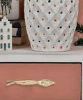 Dope Brass Bird Shape Cabinet Handles With Golden Finish on pink drawer, with white vase and decorative items on top