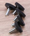 Badass Heavy Duty Adjustable Furniture Levelers With Tee Nuts Kits Black Steel And Rubber Pads For Killing Wobble On Cabinets Tables Chairs Workbenches Quick Setup close-up of black rubber topped leveler feet with threaded steel shafts on wood background