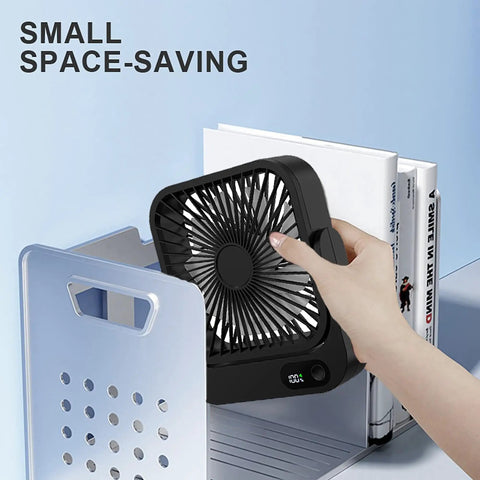 Magnetic Travel Fan With Five Adjustable Speeds Cruise Ship Approved Battery Powered Personal Cooler in black being held near books.