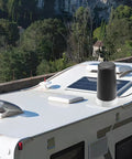 RV rooftop with installed Long Range 915MHz LoRa Antenna With Magnetic Base, SMA Male Connector visible, surrounded by trees and road.