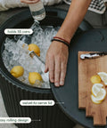 2-In-1 Outdoor Cooler Side Table In Black, Keeps 48 Cans Cold For 12 Hours, 40L Ice Capacity, swivel lid, serving board with lemons