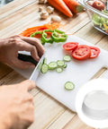 Person slicing cucumbers on a cutting board with vegetables around, featuring 24 Pack Clear Self Adhesive Rubber Feet For Glass Tables And Drawers Rock Solid Anti Slip Bumpers Total Lockdown Grip Zero Drama Slide Super Tight Peel Stick Setup.