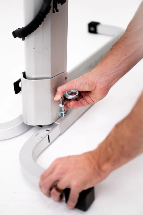 Assembling Bike Balance Trainer For Trail Ready Balance Drills, hands securing aluminum frame for strength training.
