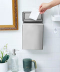 Wall-mounted stainless steel sanitary napkin receptacle in bathroom with hand disposing item into bin