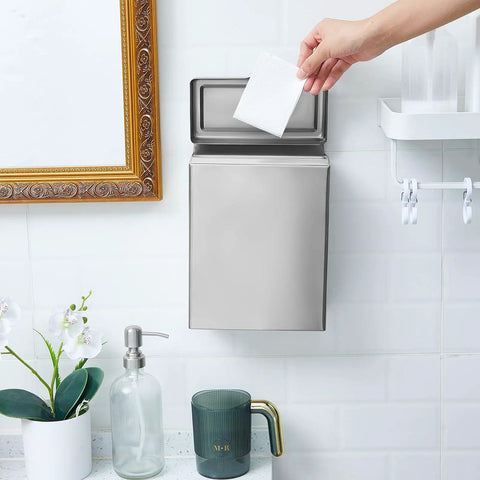 Wall-mounted stainless steel sanitary napkin receptacle in bathroom with hand disposing item into bin